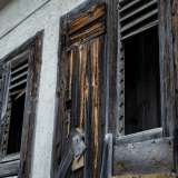 ... mentre al lato si stagliano due vecchie finestre in legno consumate dal tempo